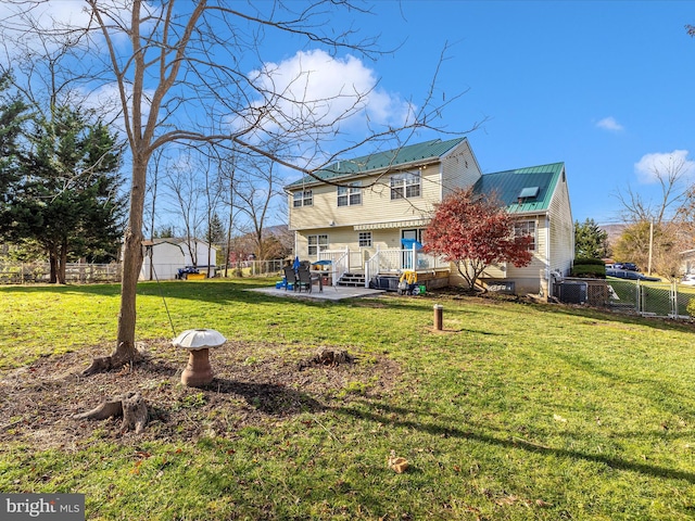 back of property with a yard, a patio, and a deck