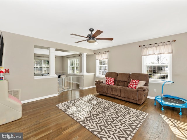 living room featuring hardwood / wood-style flooring, ceiling fan, and ornate columns