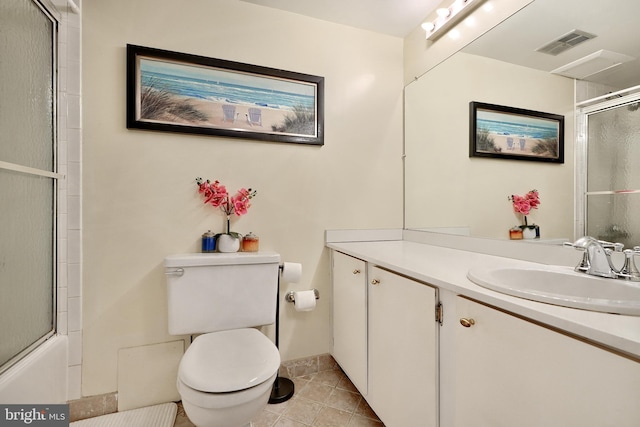 full bathroom featuring tile patterned floors, vanity, bath / shower combo with glass door, and toilet