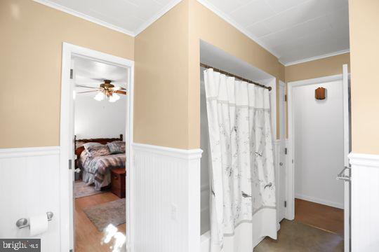 bathroom featuring ceiling fan and ornamental molding