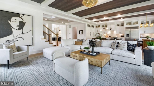 living room with beamed ceiling and a notable chandelier