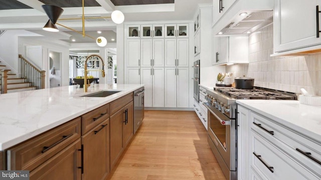 kitchen featuring light stone countertops, appliances with stainless steel finishes, tasteful backsplash, sink, and white cabinets