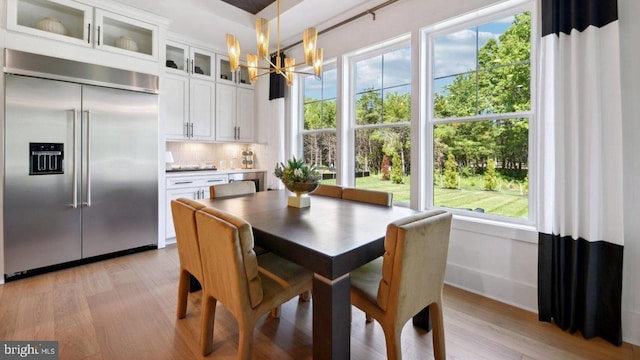 dining space featuring an inviting chandelier and light wood-type flooring