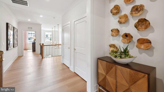 corridor featuring light hardwood / wood-style flooring and ornamental molding