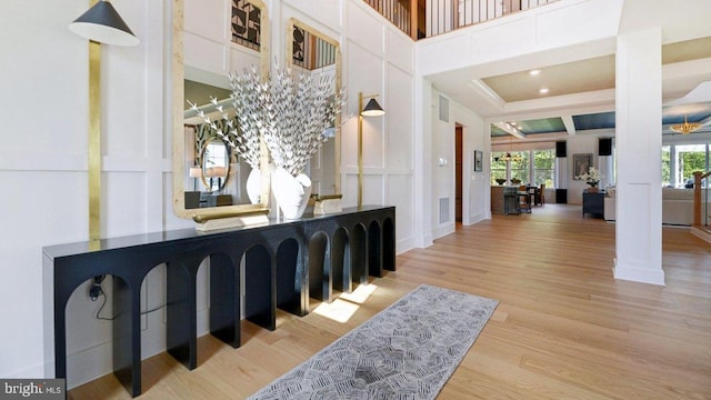 interior space with decorative columns, a high ceiling, and hardwood / wood-style flooring