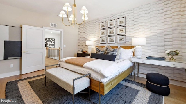 bedroom featuring light hardwood / wood-style floors and a notable chandelier