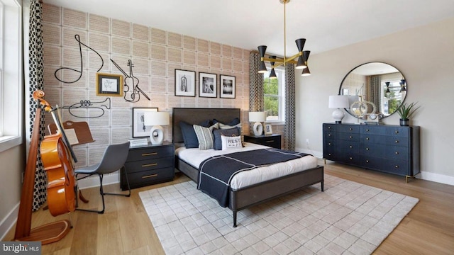 bedroom with brick wall and light hardwood / wood-style flooring