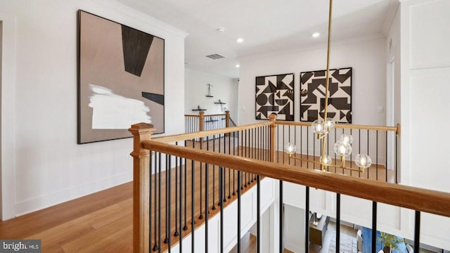 hallway with hardwood / wood-style flooring and crown molding