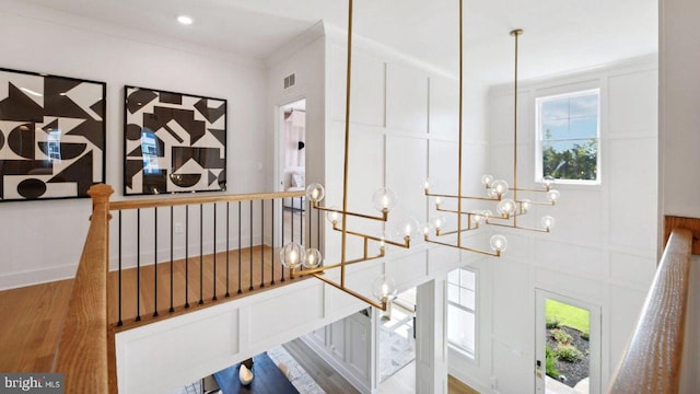 details with crown molding, a chandelier, and hardwood / wood-style flooring