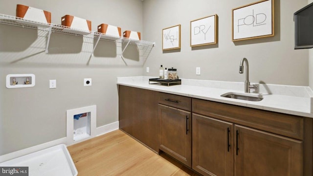 washroom with sink, electric dryer hookup, cabinets, washer hookup, and light wood-type flooring