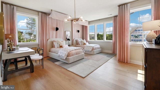 bedroom with light hardwood / wood-style flooring and a chandelier