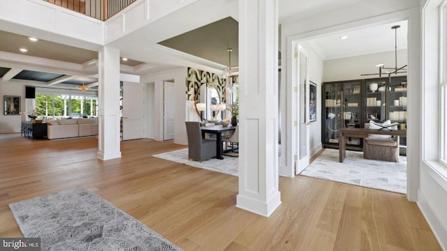 foyer entrance with decorative columns, coffered ceiling, and light hardwood / wood-style flooring