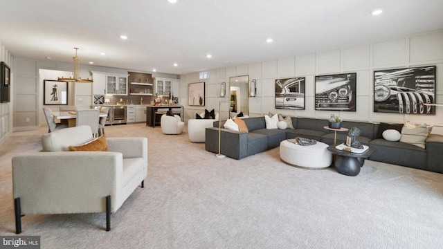 carpeted living room with a chandelier