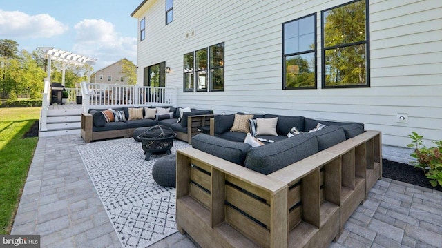 view of patio with an outdoor living space with a fire pit and a deck