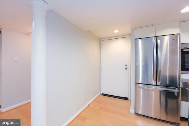 kitchen featuring ornate columns, white cabinets, light hardwood / wood-style floors, and appliances with stainless steel finishes