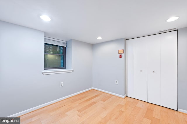 unfurnished bedroom featuring light wood-type flooring and a closet