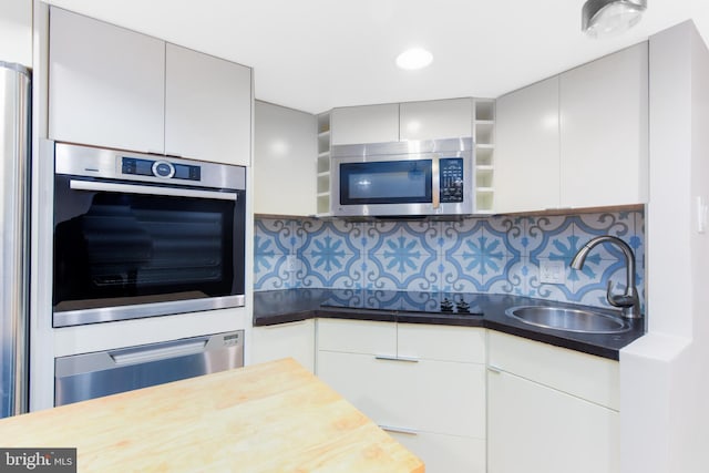 kitchen featuring decorative backsplash, gray cabinets, sink, and stainless steel appliances