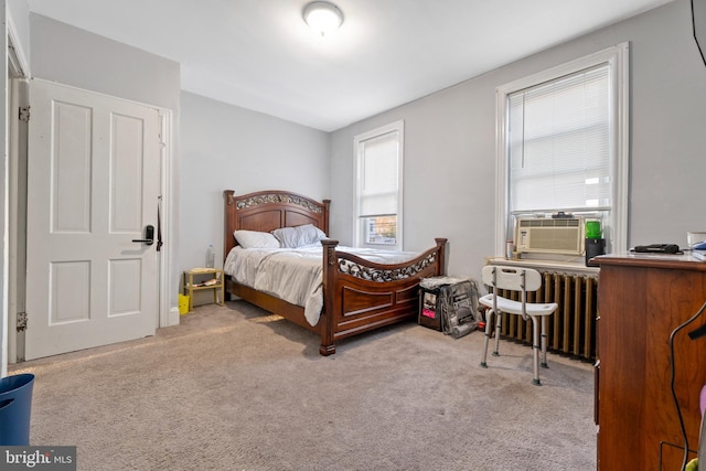 bedroom with light carpet, radiator heating unit, and cooling unit