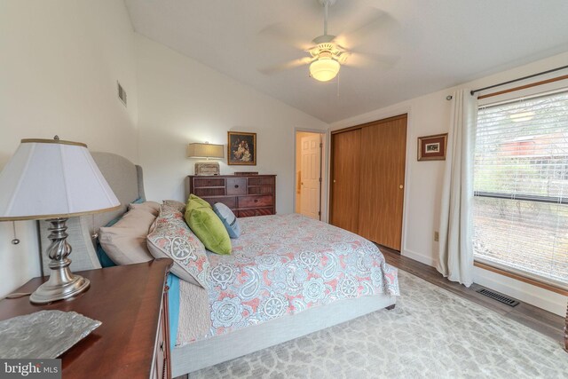 bedroom with a closet, ceiling fan, hardwood / wood-style floors, and lofted ceiling