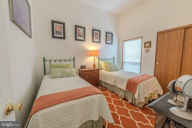 bedroom with dark hardwood / wood-style floors and a closet