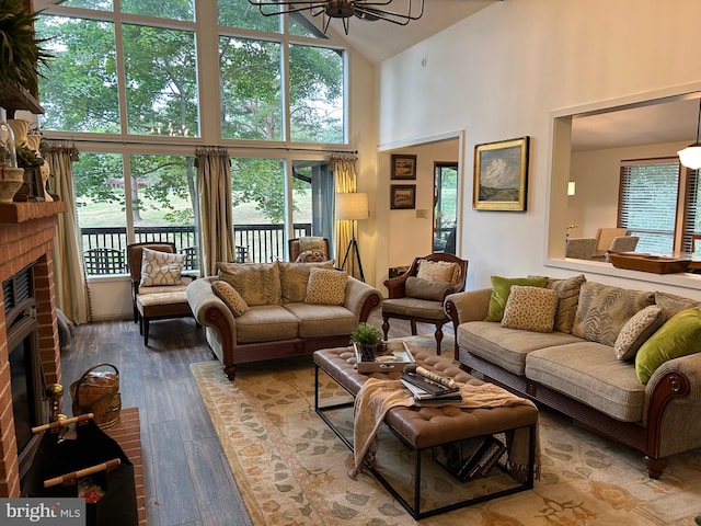 living room featuring a brick fireplace, high vaulted ceiling, and hardwood / wood-style flooring