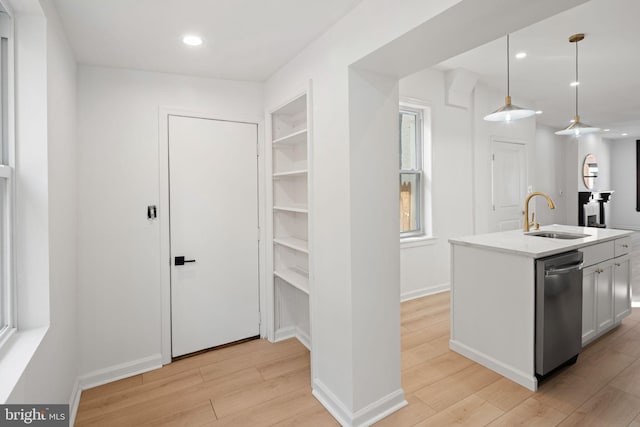 kitchen with dishwasher, sink, light hardwood / wood-style floors, and decorative light fixtures