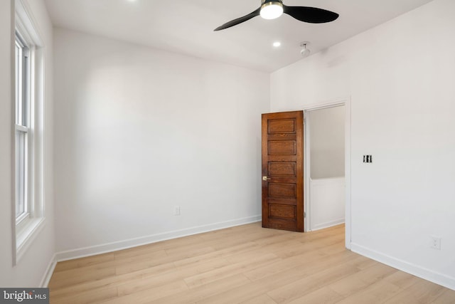 empty room featuring plenty of natural light, ceiling fan, and light hardwood / wood-style flooring