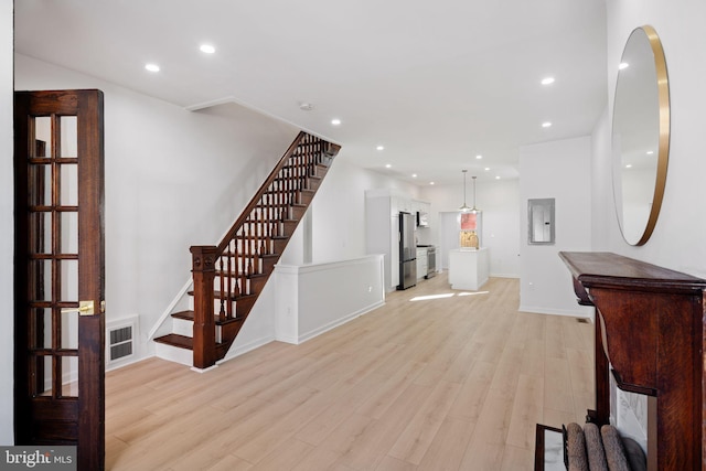 unfurnished living room with light hardwood / wood-style floors and electric panel