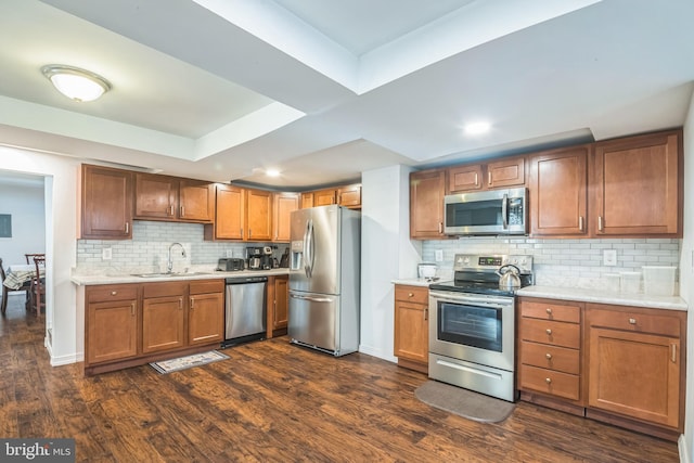 kitchen with backsplash, sink, appliances with stainless steel finishes, and dark wood-type flooring