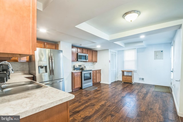 kitchen featuring dark hardwood / wood-style flooring, sink, appliances with stainless steel finishes, and tasteful backsplash