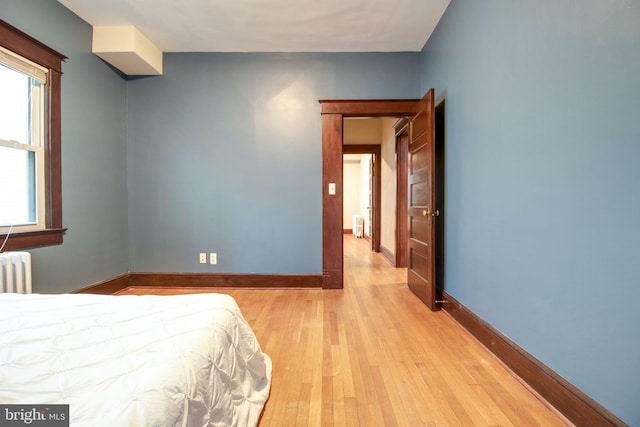 bedroom featuring light wood-type flooring and radiator heating unit