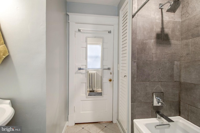 bathroom featuring tile patterned flooring and tiled shower / bath