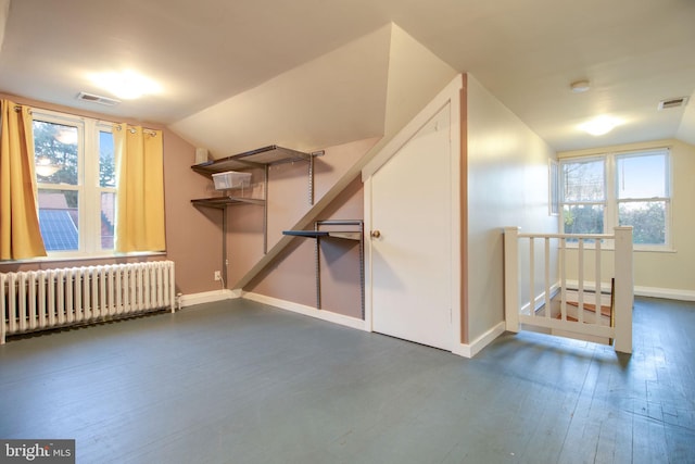 additional living space with dark hardwood / wood-style flooring, radiator heating unit, and vaulted ceiling