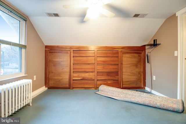 unfurnished bedroom with ceiling fan, lofted ceiling, and radiator