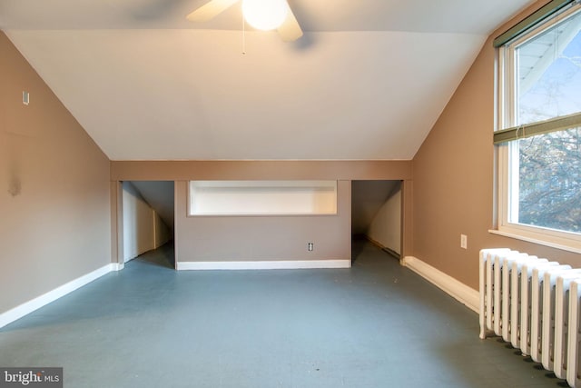 additional living space featuring plenty of natural light, lofted ceiling, and radiator