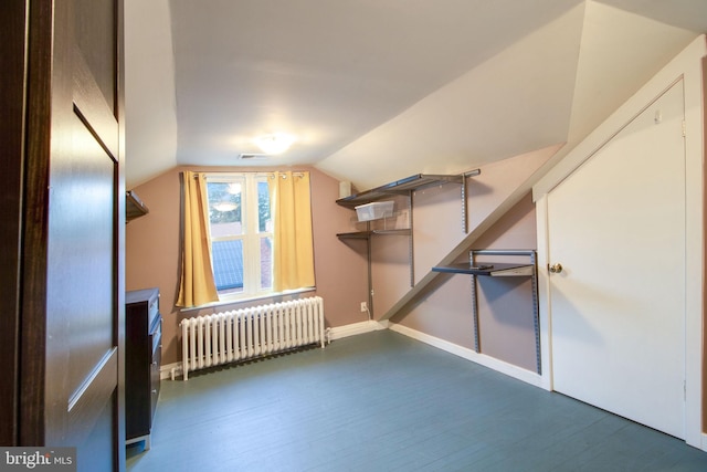 bonus room with dark hardwood / wood-style flooring, radiator heating unit, and lofted ceiling