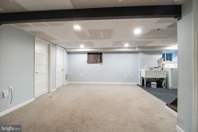 basement with carpet flooring, washer / dryer, and sink