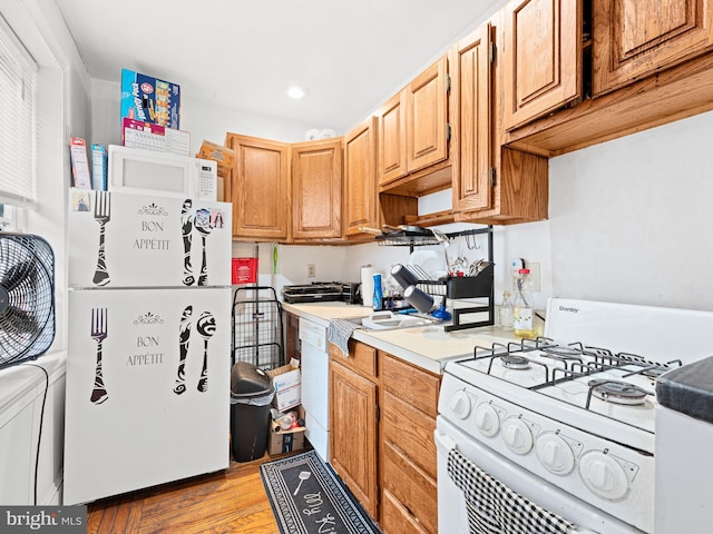 kitchen featuring white appliances and light hardwood / wood-style flooring