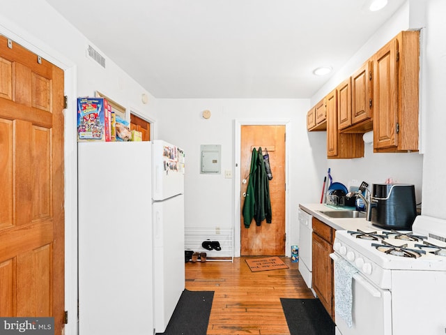 kitchen featuring white appliances, light hardwood / wood-style flooring, and sink