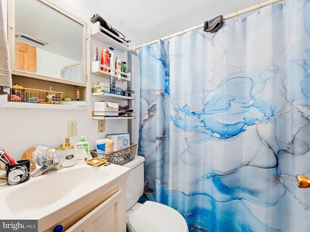 bathroom featuring a shower with curtain, toilet, and sink