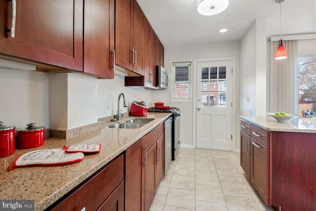 kitchen featuring light stone countertops, sink, stainless steel appliances, hanging light fixtures, and light tile patterned flooring