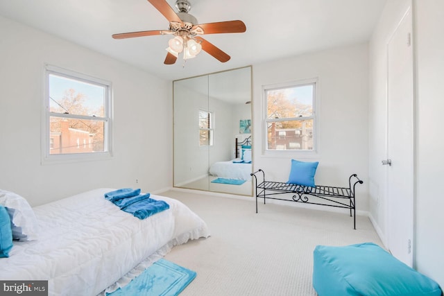 carpeted bedroom featuring ceiling fan and a closet