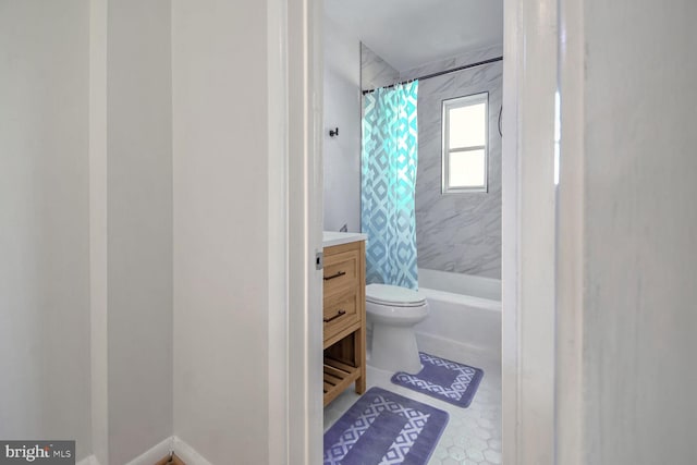 full bathroom with tile patterned floors, shower / bathtub combination with curtain, vanity, and toilet