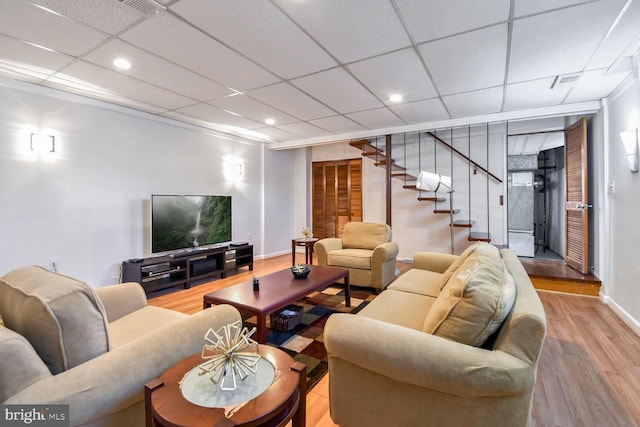 living room with hardwood / wood-style floors and a drop ceiling