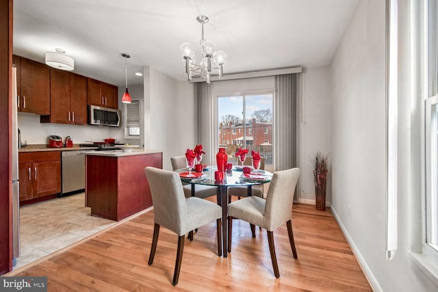 dining area with a notable chandelier and light wood-type flooring