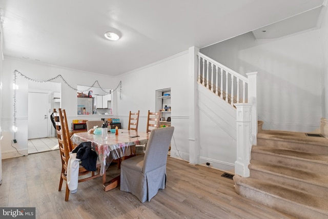 dining area featuring hardwood / wood-style floors and ornamental molding