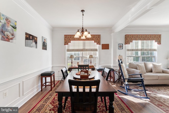 dining area with crown molding, wood-type flooring, and a notable chandelier