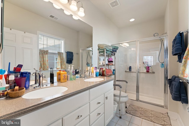 bathroom with a shower with shower door, tile patterned floors, vanity, and toilet