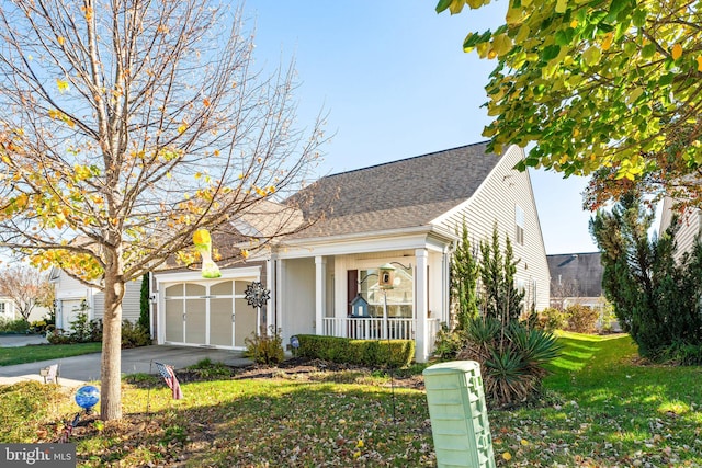 view of front of house with a front yard, covered porch, and a garage