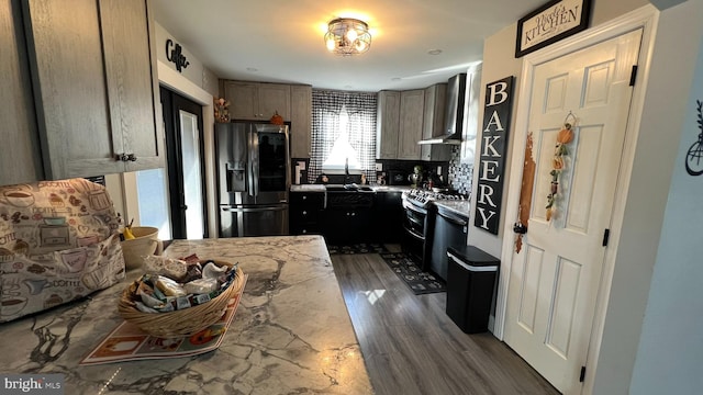 kitchen with stainless steel fridge, a sink, wall chimney range hood, double oven range, and backsplash